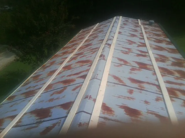 Rusted metal roof panels with new wood purlins before replacement — Storm Damage Roof Repair in Childersburg by Roofing Brothers