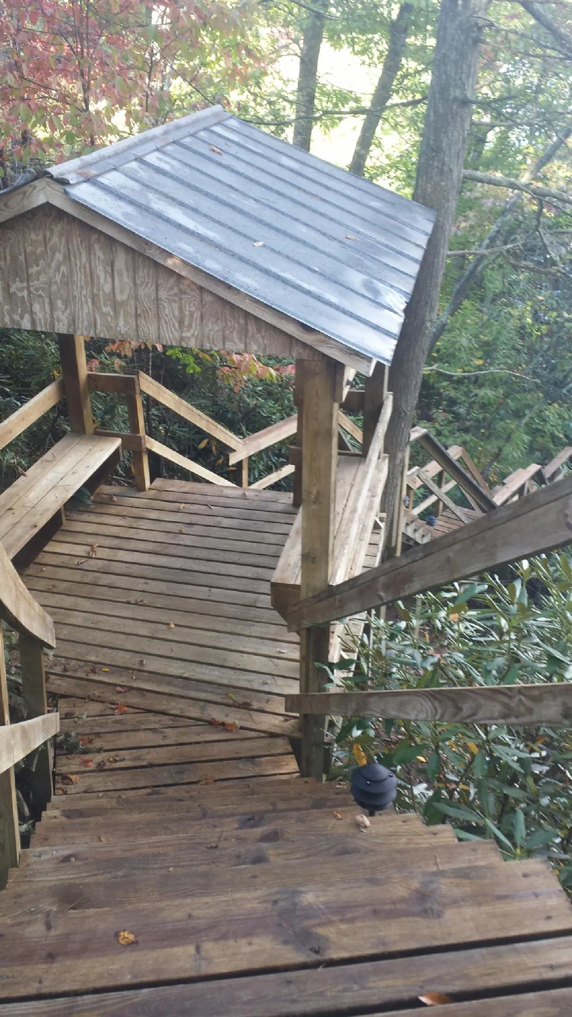 Metal roofed shelter over wooden steps on a wooded walkway — Skylight Repair & Installation work by our crew in Childersburg