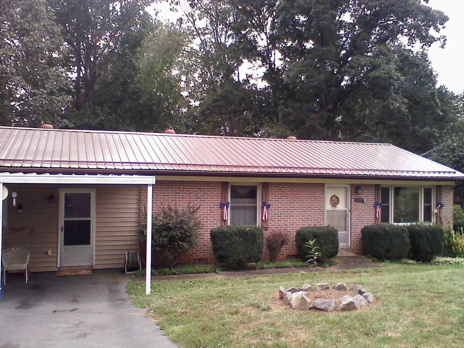 Bronze metal roof and carport on a brick ranch home — Roof Repair work by our crew in Childersburg
