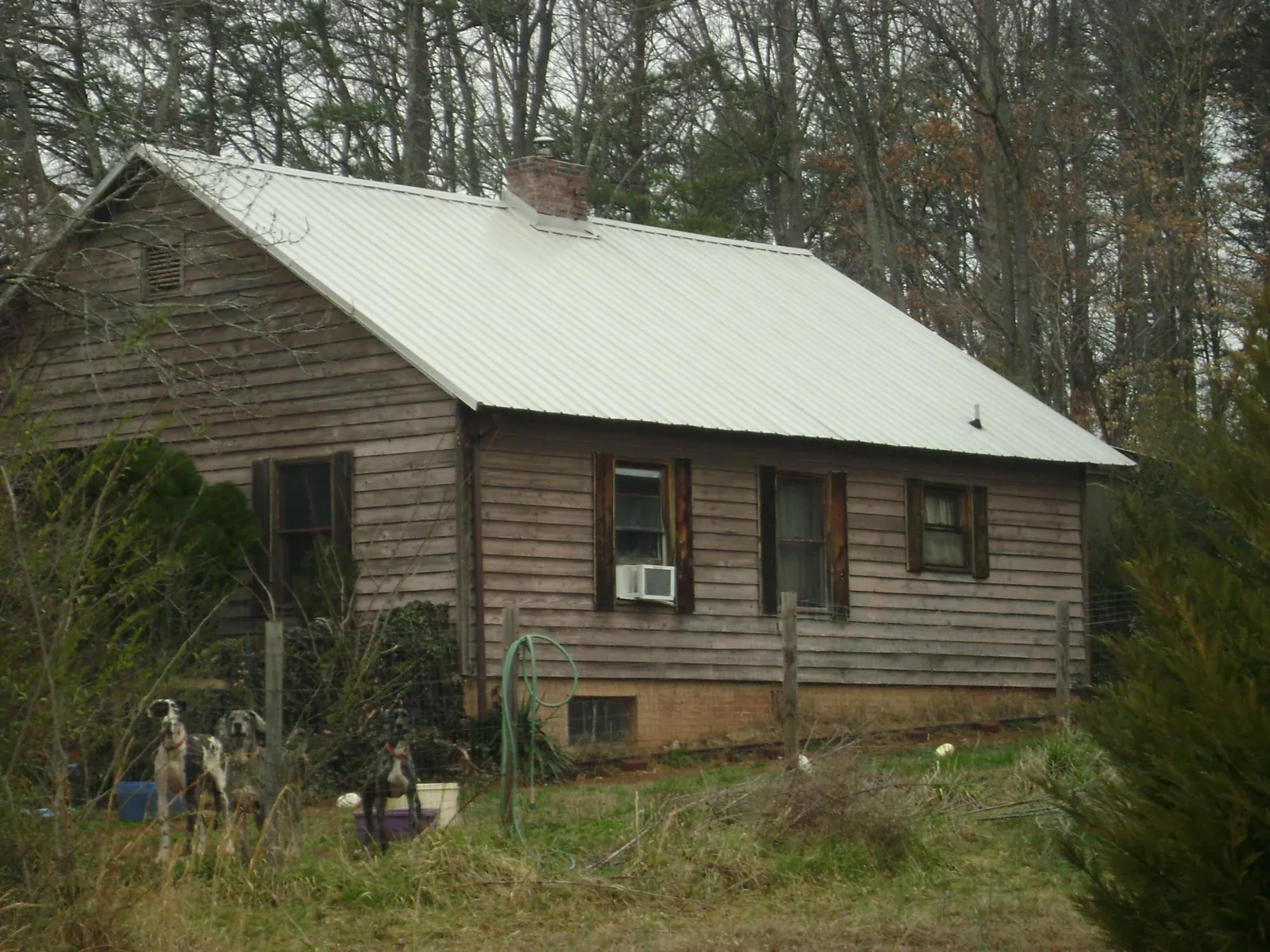 White metal roof on an old wood sided farmhouse, from a Asphalt Shingle Roof Repair job in Childersburg